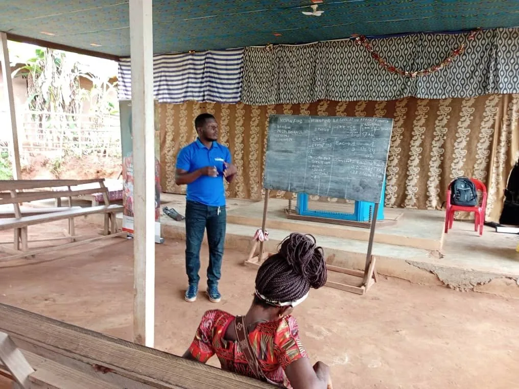 Un agent VisionFund by AfriCap présente l'épargne et le crédit au tableau